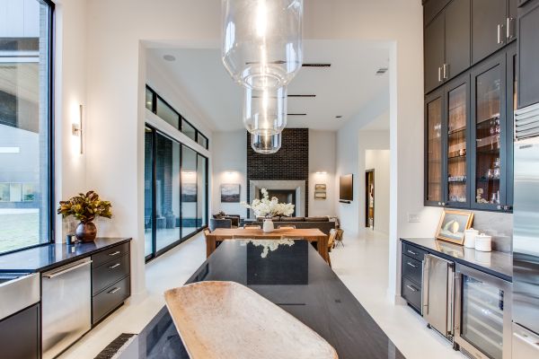 Custom kitchen with black kitchen counter, black kitchen cabinet, and white floors