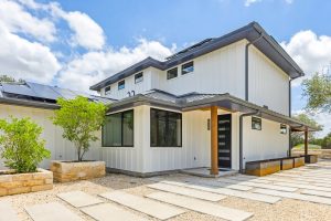 Green home with white walls and metal roof