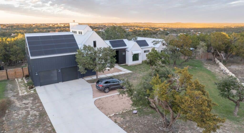 Exterior view of a custom Build Native home with solar panels on the roof. 